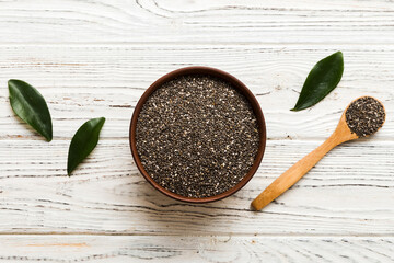 Chia seeds in bowl and spoon on colored background. Healthy Salvia hispanica in small bowl. Healthy superfood