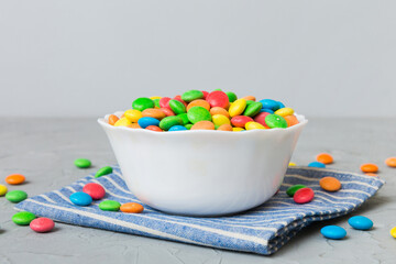 Multicolored candies in a bowl on a colored background. birthday and holiday concept. Top view with copy space