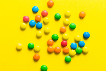 Mixed collection of colorful candy, on colored background. Flat lay, top view. frame of colorful chocolate coated candy