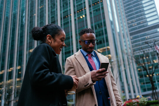 Business people using smart phone app outside office building