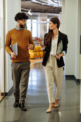 Colleagues walking and discussing something in the office