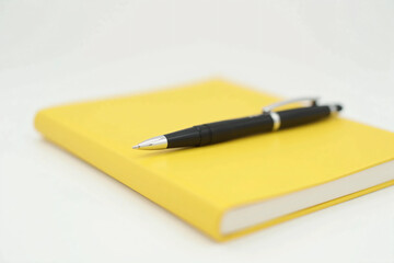 A Sleek Black Pen with Silver Accents Resting Diagonally on a Blank Notebook – Minimalist Composition with Soft Shadows, Glossy Finish, and a Professional Aesthetic