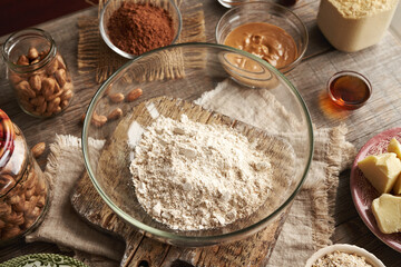 Whey protein powder, ground oat flakes, nut butter, maple syrup and raw cacao - ingredients for homemade protein bars