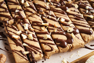 Closeup of homemade snack bars made with whey protein powder, ground oat flakes, maple syrup, cinnamon and nut butter