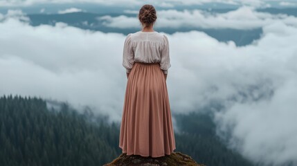 Fototapeta premium Woman Standing on Mountain Edge Overlooking Foggy Landscape