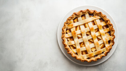 Lattice-top apple pie on white plate with golden crust on light background.