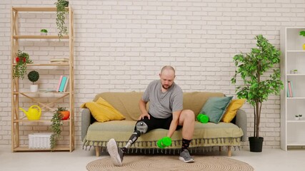 A man with a prosthetic leg sits on a couch in a cozy living room, doing an exercise with dumbbells, training his arms.