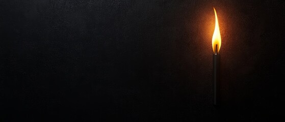 Fototapeta premium A lone matchstick flickers against a dark background, symbolizing light in darkness and the power of small beginnings.