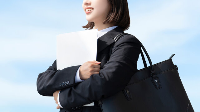 青空と就活生・新入社員の若い女性