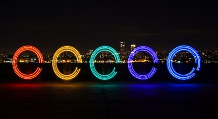 Vibrant Rainbow Light Circles Illuminate Night Cityscape During Pride Celebration