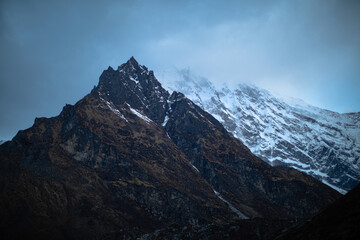 Obraz premium A mountain covered in snow with a cloud in the sky
