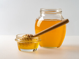 Natural organic honey in glass jar, honey dipper and honeycombs are near. Natural food background.
