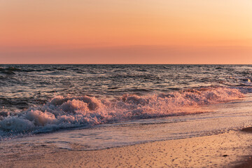 Obraz premium Black sea shore at sunset, pink clouds, water, beach, relaxation.