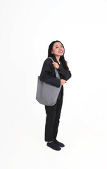 Standing woman with long hair wearing denim jacket and black pants carrying gray colored tote shoulder bag isolated on vertical white background.