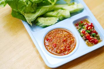 Nam Phrik Kapi, the spicy shrimp paste dipping sauce of traditional food with chili fish sauce is aside,, view from above. Close-up food image.