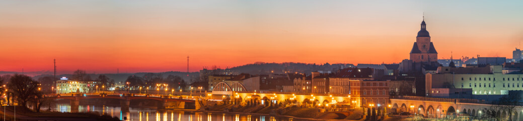 Obraz premium Gorzow Wielkopolski skyline view of St. Mary's church tower and Warta river at sunset. Poland