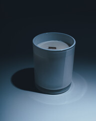 White candle in a matte candlelight with a wooden wick on a black and white gradient background
