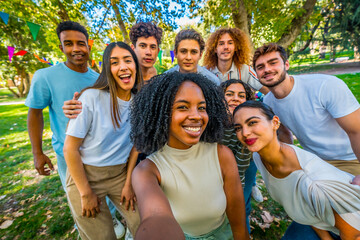 Happy african woman taking selfie with multi-ethnic friends in park