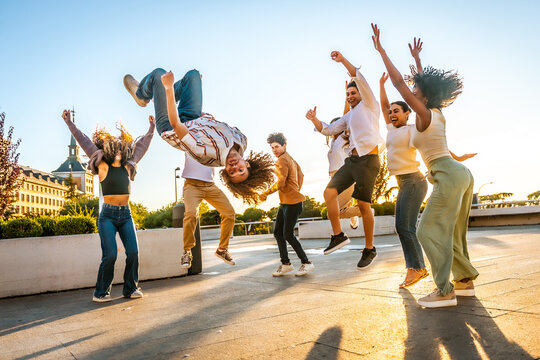 Man performing a back flip having fun with friends outdoors