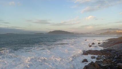 Fototapeta premium Stunning coastal view of Baiona, Galicia, with waves crashing against rocky shores under a serene sky, capturing the natural beauty and tranquility of the seascape