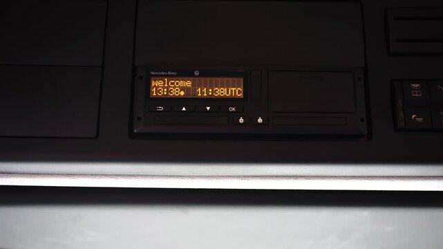Driver operating tachograph in vehicle, symbolizing transport control, road safety, data recording, logistics monitoring, and professional driving routine.