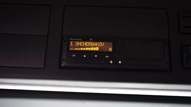Driver operating tachograph in vehicle, symbolizing transport control, road safety, data recording, logistics monitoring, and professional driving routine.