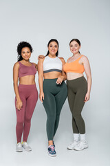 Obraz premium Three strong women showcase fitness and unity in vibrant sportswear during a dynamic photoshoot