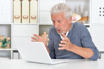 Fototapeta premium Portrait of senior man with laptop at home