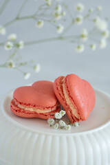 French macarons in the shape of red heart on light background, perfect for st Valentine's day and mother's day 