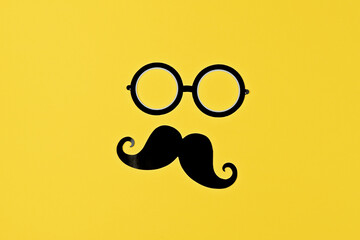 Moustache and glasses silhouette pop on bold yellow surface, showcasing playful style, playful...