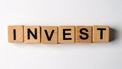 Wooden alphabet blocks arranged to spell invest, symbolizing foundational concepts in business and growth strategies.