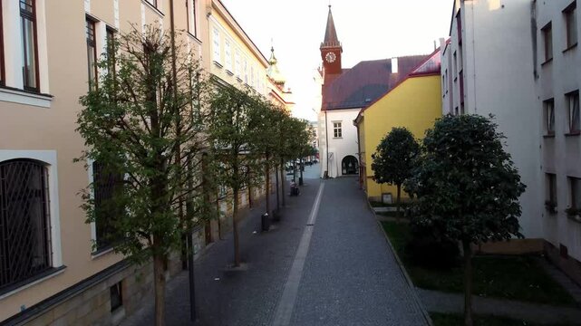 Drone video of a picturesque Czech town with red-tiled roofs and historic churches. Aerial view captures the charming architecture, narrow streets, and timeless beauty of the city.