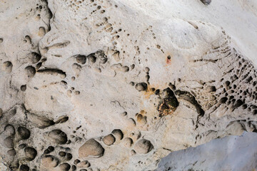 Weathered coastal sandstone rock on stone coastline in overcast morning