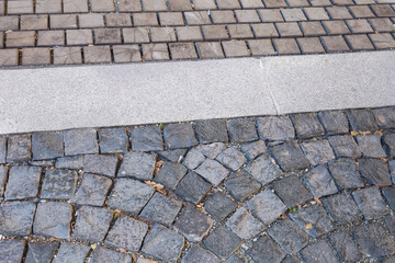 Footpath paved with square stone slabs and transverse wooden logs