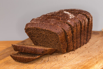 Sliced brown bread on cutting board, front view close-up
