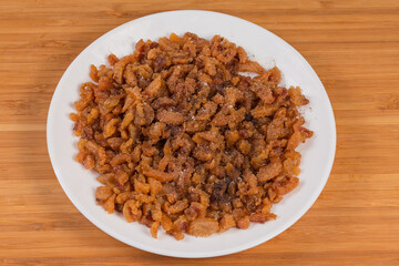Duck сracklings sprinkled with salt and ground pepper on dish
