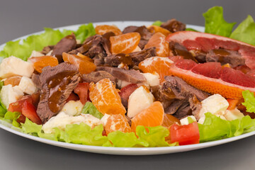 Salad with boiled duck meat, mozzarella, citrus, vegetables and greens