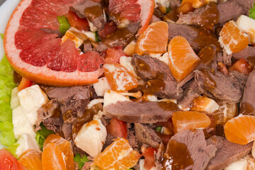 Salad with boiled duck meat, mozzarella, citrus, vegetables and greens