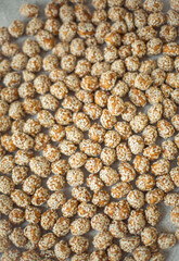 candied peanut candies in sesame seeds on the table