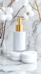 Elegant White Soap Dispenser with Cotton Blossoms - White ceramic soap dispenser with gold pump, displayed on white cotton rounds, beside cotton blossoms on marble.