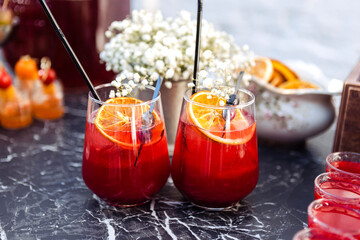 Close-up of two glasses with a berry cocktail on a black marble table