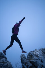 Determined Woman Trail Running at Night, Illuminated by a Headlamp in the Mountain Wilderness.