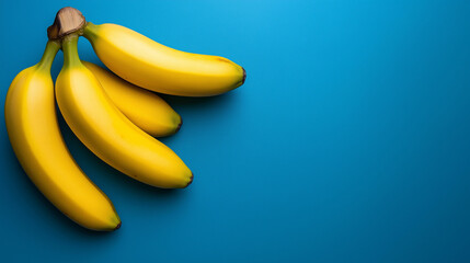 Fresh ripe bananas on vibrant blue background, ideal for healthy eating advertisements, tropical-themed designs, and nutrition blog visuals. Copy space