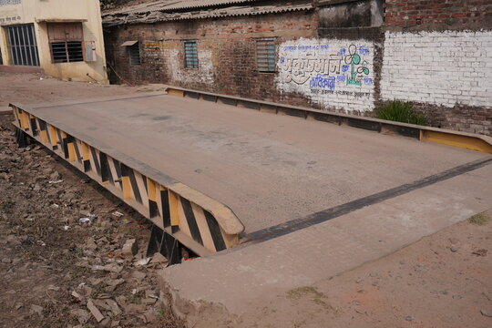 A weighbridge or truck scale which is used for weighing entire road vehicles and their contents