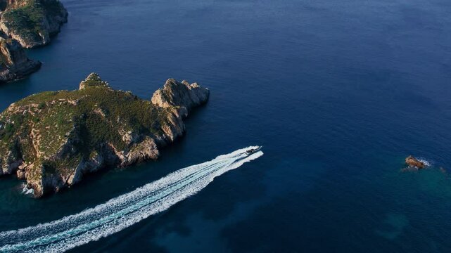 Luxurious speed motor boat passing by Islas Malgrats in Mallorca, Spain towards mainland. Mediterranean vacation holiday spot. Views of Mallorca mountain range