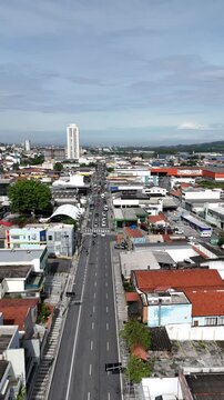 V&iacute;deo vertical da Rua Ipiranga em Mogi das Cruzes, SP, Brasil, mostrando o movimento de carros e a din&acirc;mica urbana da cidade, destacando a infraestrutura e o tr&aacute;fego local