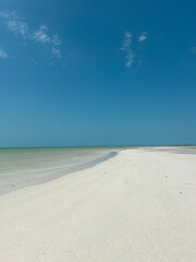 White sand beach with blue sky and no people