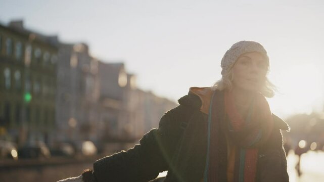 Lonely senior woman in casual clothing walking in city in winter day, portrait. Carefree and happy blonde lady strolling and breathing cold air, female city dweller enjoying solitude and calmness