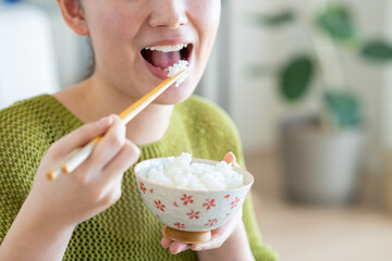朝食にごはんを食べる若い女性
