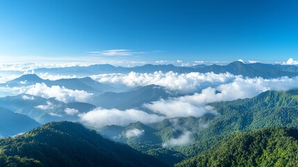 Breathtaking mountain landscape under a clear blue sky, with lush green hills and clouds rolling through the valleys. A perfect scene capturing the beauty of nature and serenity.